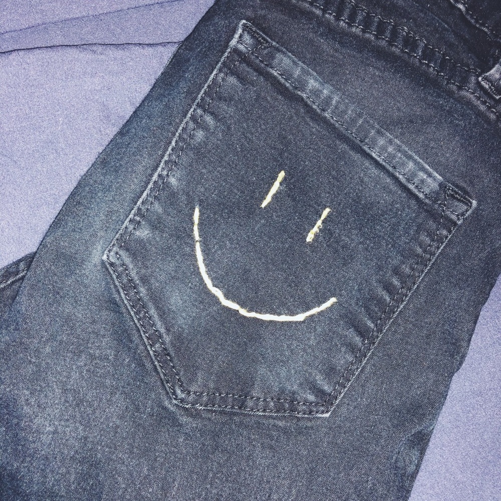 Distressed ripped knee smiley embroidered jeans